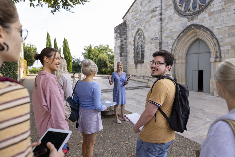kids on a college tour looking a old brick building