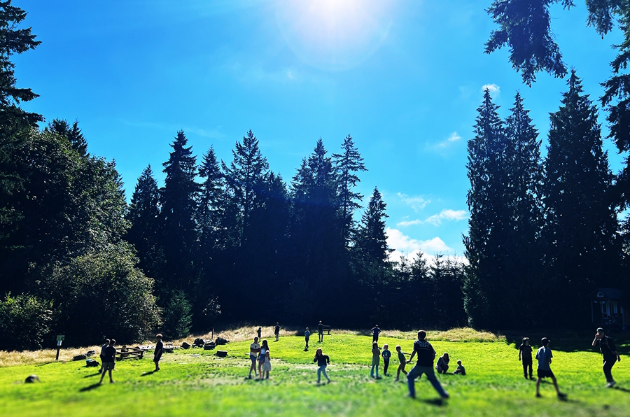 kids playing outside in a big grass field on a sunny day 