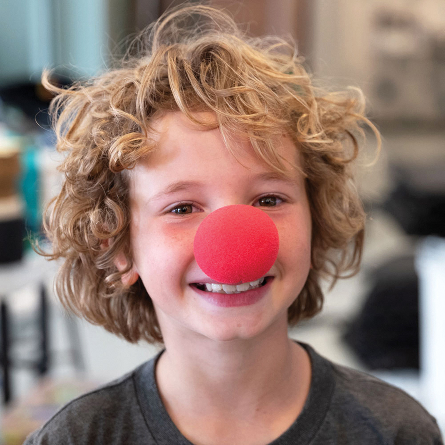 kid wearing a clown nose