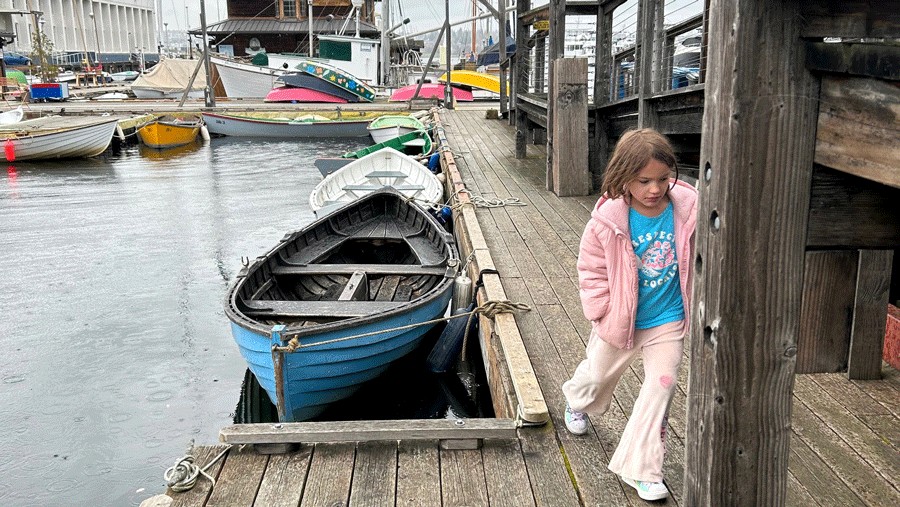 young girl walking by boats outside the Center for Wooden Boat's Livery on South Lake Union