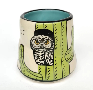 a ceramic cup with an owl painted on it