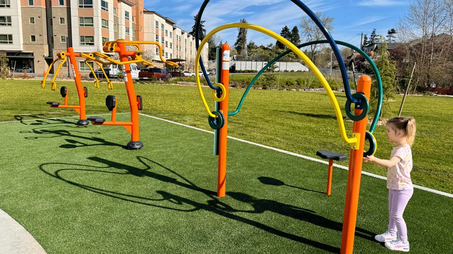 Young girl looking at fitness equipment at Cheryl Chow Park in Seattle