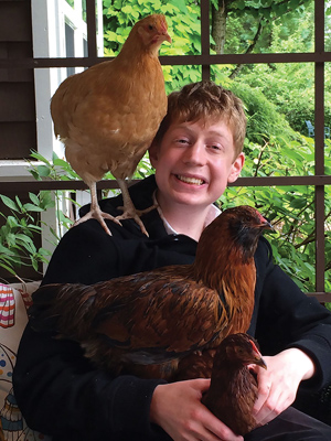 The author's son poses with his pet chickens. Photo credit: Kristin Jarvis Adams