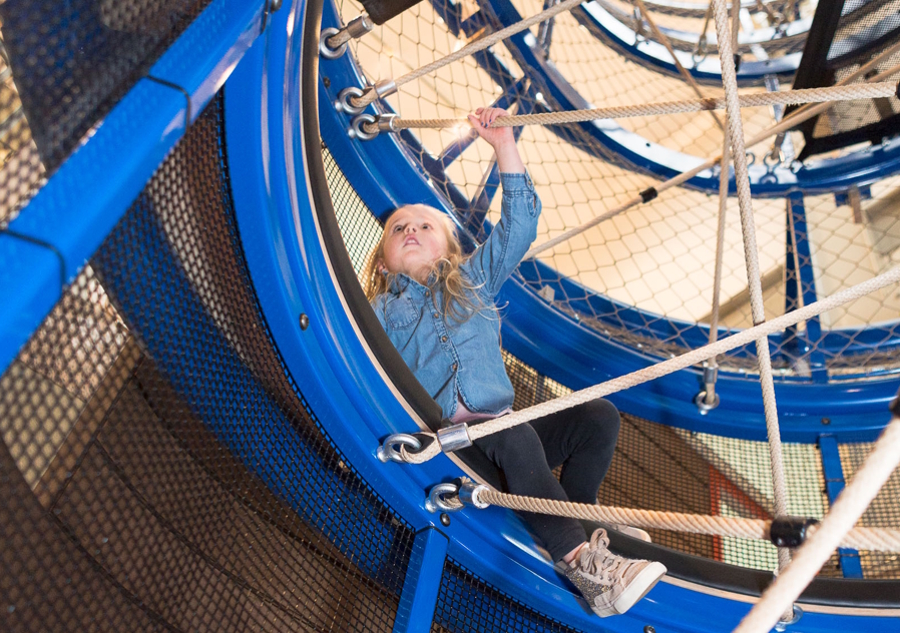 a young girl climbing at KidsQuest children's Museum