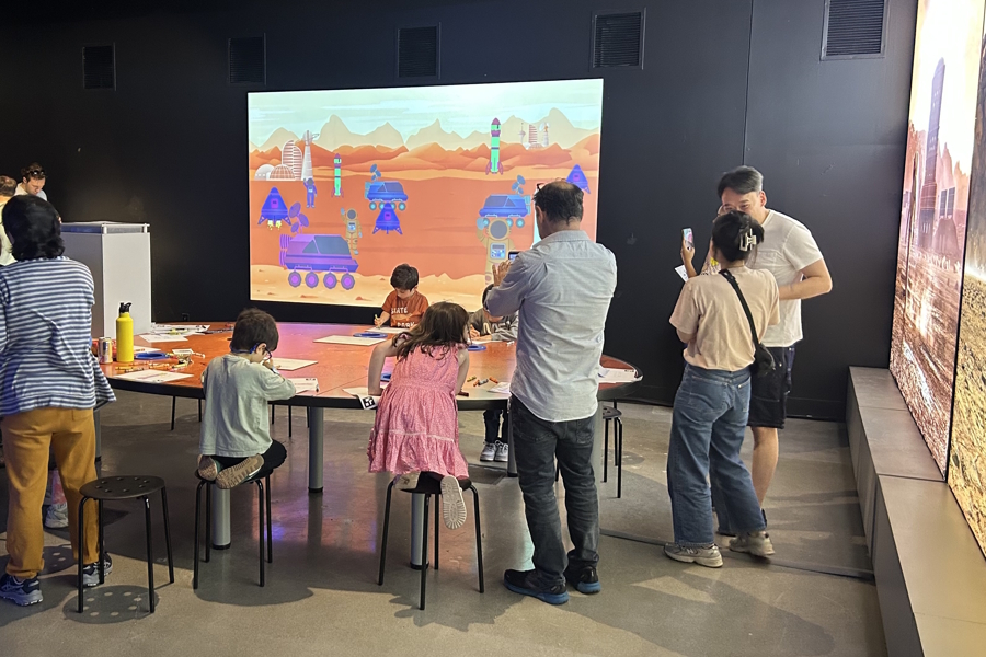 kids coloring pictures that will appear on a projected screen behind them