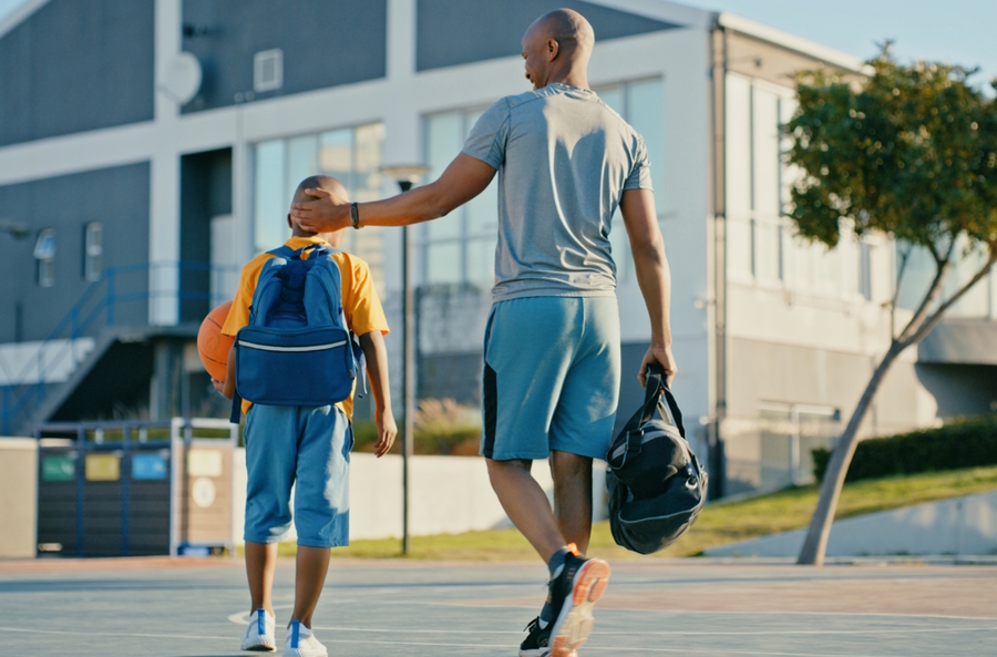 dad walking away from basketball court with son