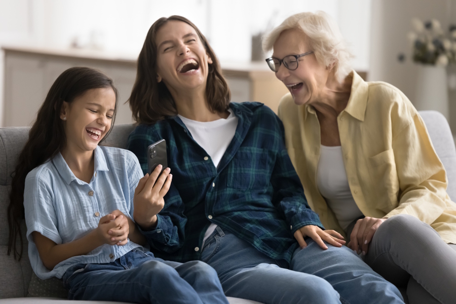daughter, mom and grandma all laughing at a cell phone family game