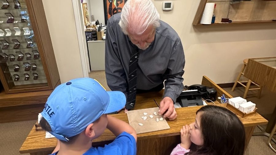 Kids in jeweler looking at rocks for a mothers day gift