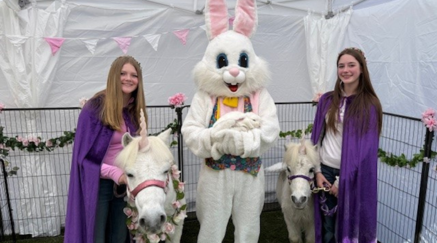 Teen girls with unicorns are waiting to meet children with the Easter Bunny.