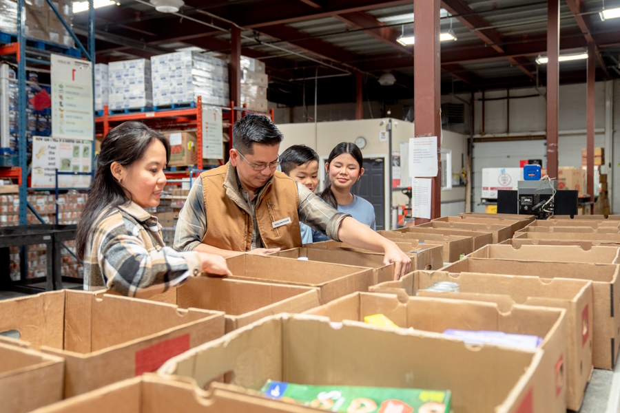 family in a food bank filling boxes for a donation