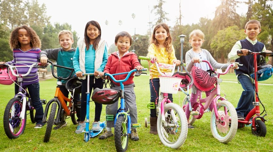 Boys and girls on bikes and geared up for a community bike rodeo.