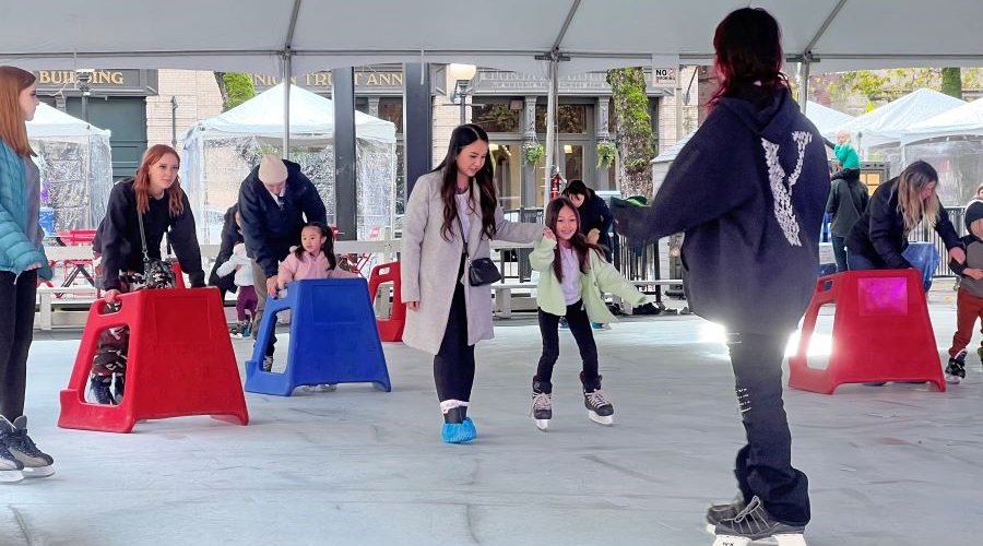 Families ice skate at a seasonal pop up rink in Seattle.