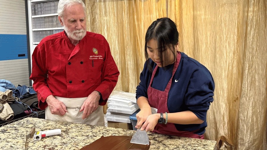 A girl learning how to make chocolate during a family-friendly class with the Chocolate Man