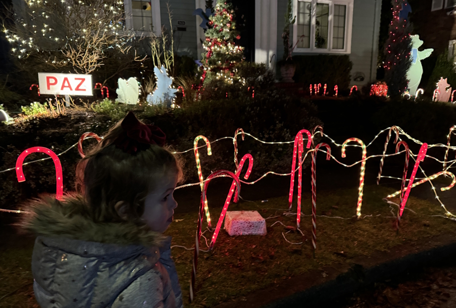 little girl walking by a house on Candy Cane Lane