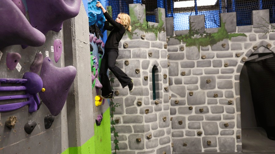 girl climbing next to a castle at Half Moon Bouldering