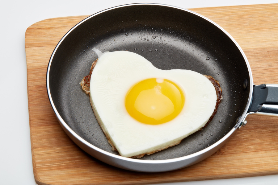 eggs in the shape of a heart in a pan
