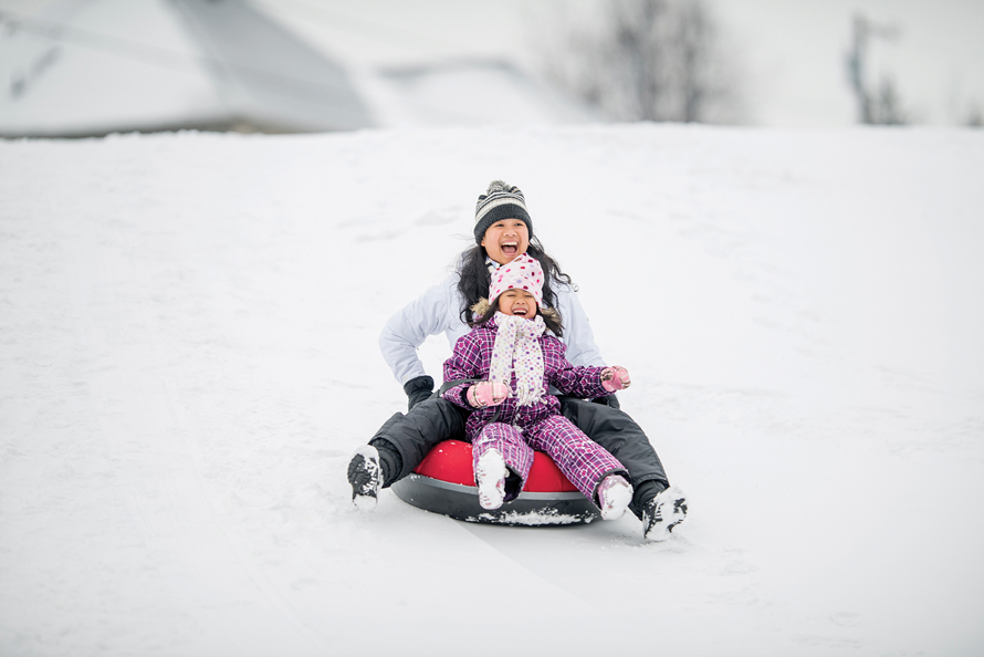 mom and kid tubing in the snow