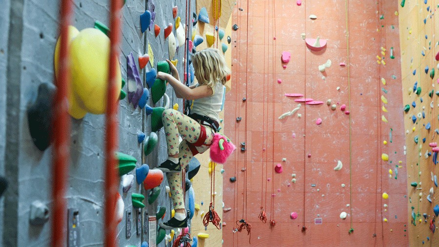 young girl top rope climbing at an indoor rock climbing gym in Seattle