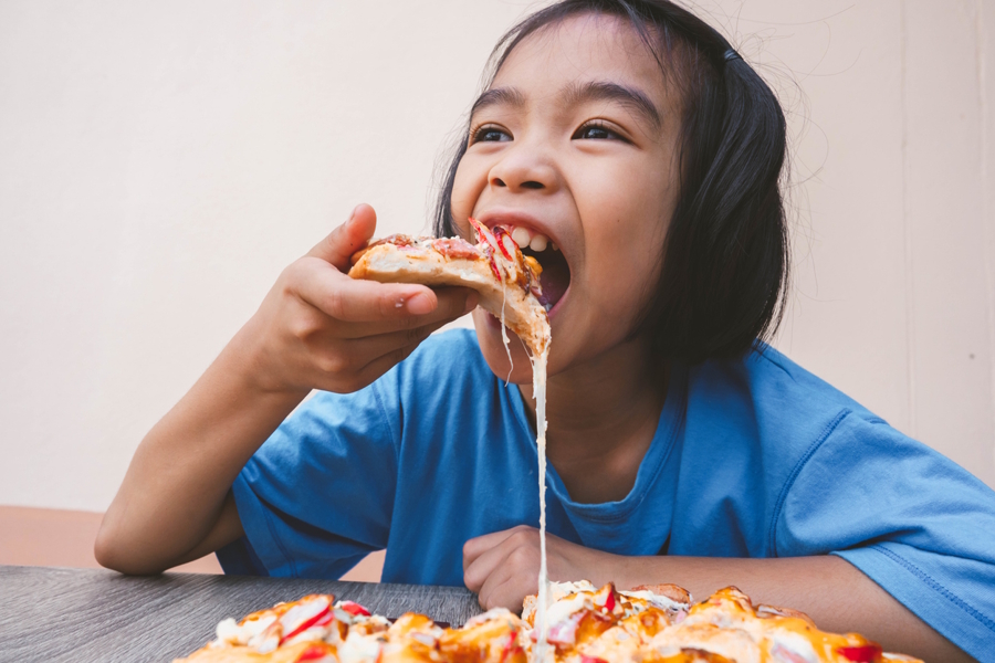 child eating a slice of pizza