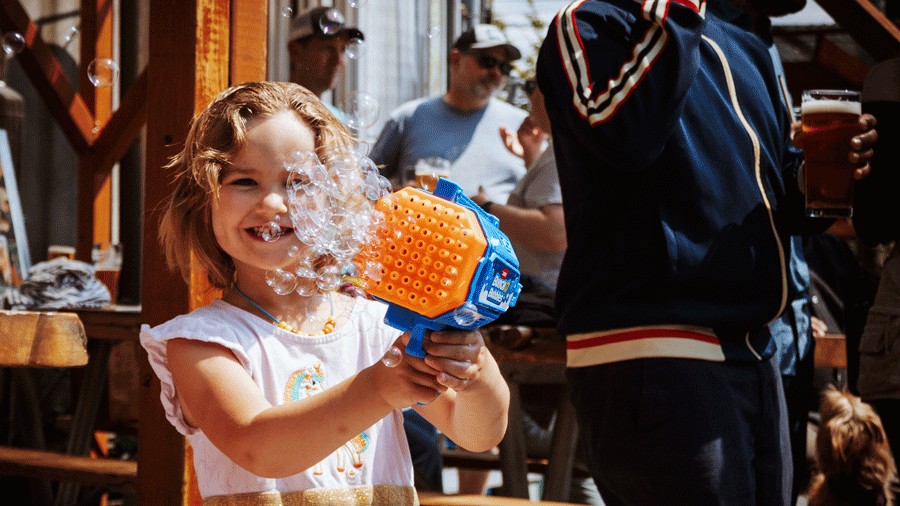 young girl blowing bubbles outside Stoup, a family-friendly brewery in Seattle