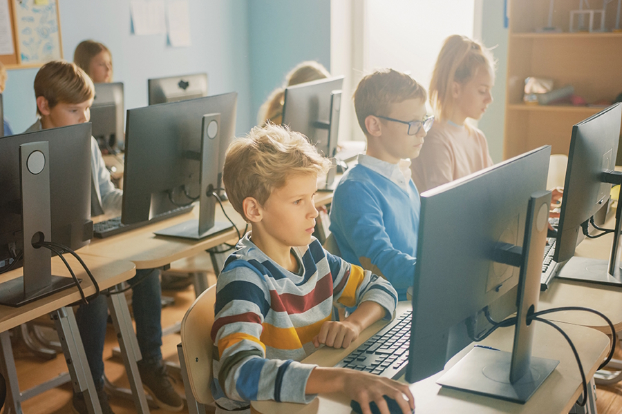 kids sitting in a classroom all using computers