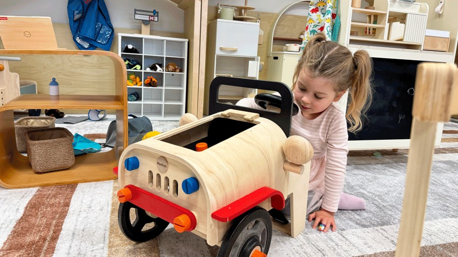 young kid exploring the wooden toys and pretending to be a car mechanic at Laro Tayo