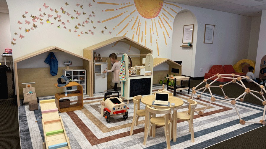 young child exploring the indoor play space at Laro Tayo in Kent, complete with a play kitchen and climbing gym