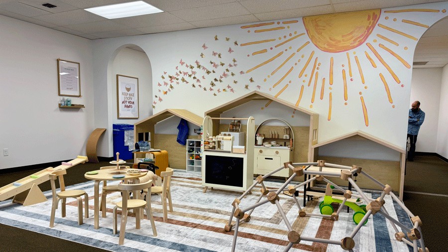 play area at Laro Tayo with imaginative toys, wooden houses, a climber and a bright mural