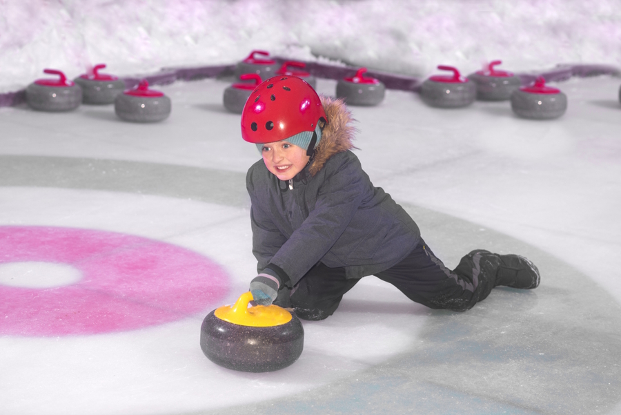 child on ice with curling stone