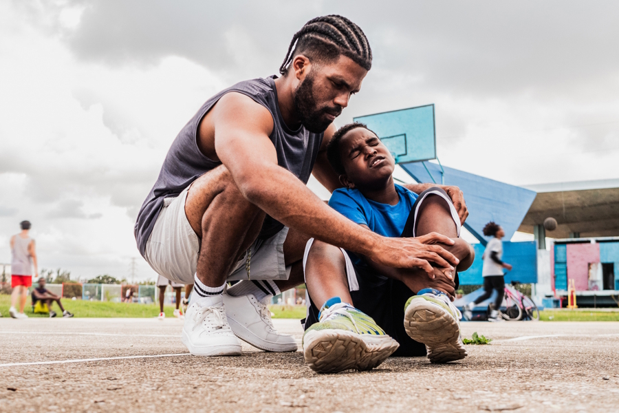 child with a hurt ankle on a basketball court
