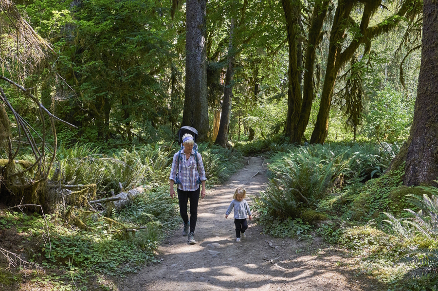 Mom and young daughter hiking in the woods