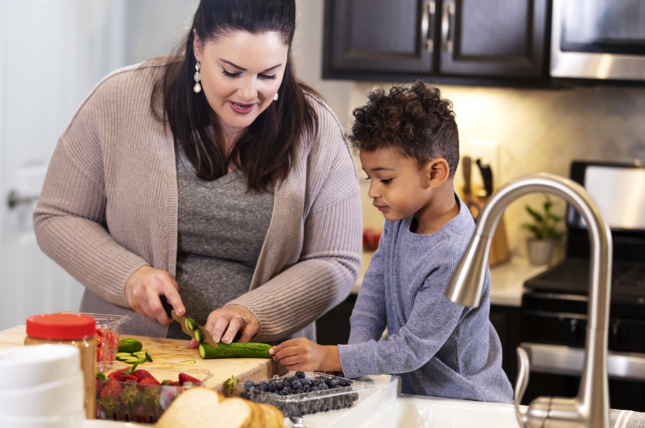 mom and child cutting up veggies to eat for lunch