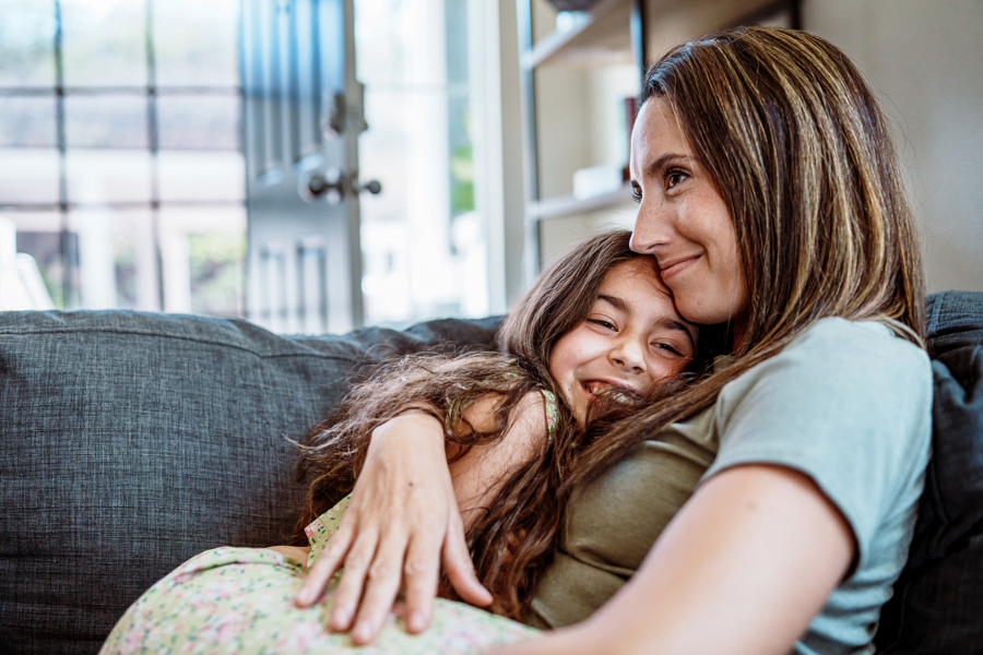 mom hugging daughter on the couch