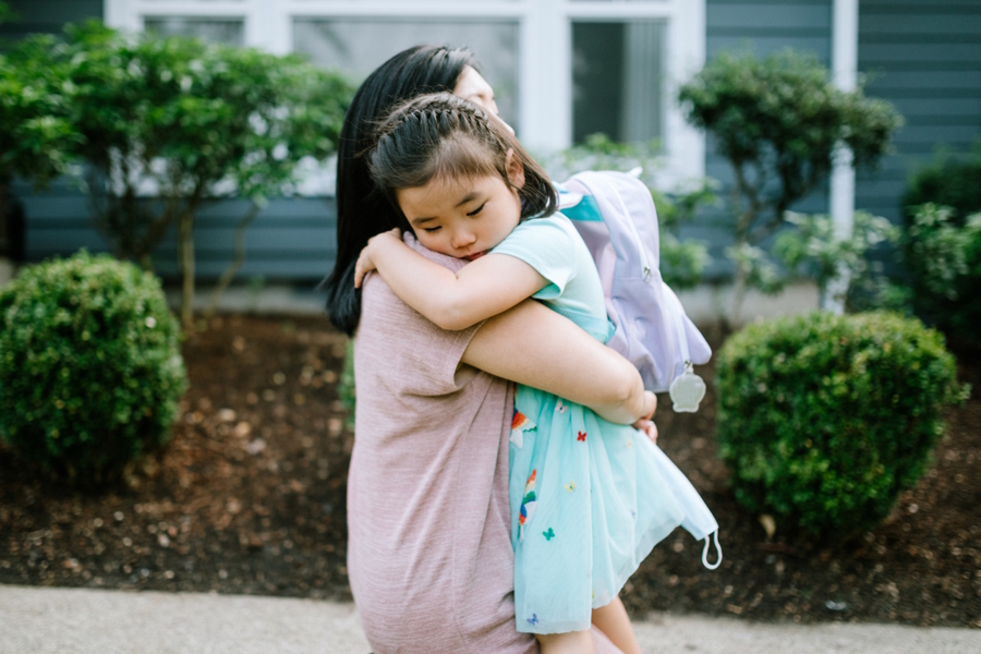 Mom hugging daughter on first day of school