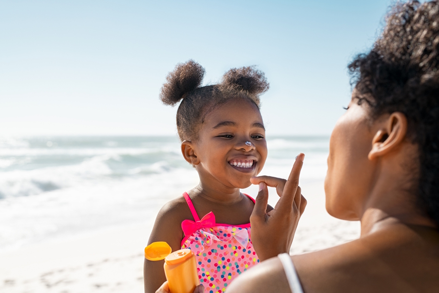 Mom putting sunscreen on daughter