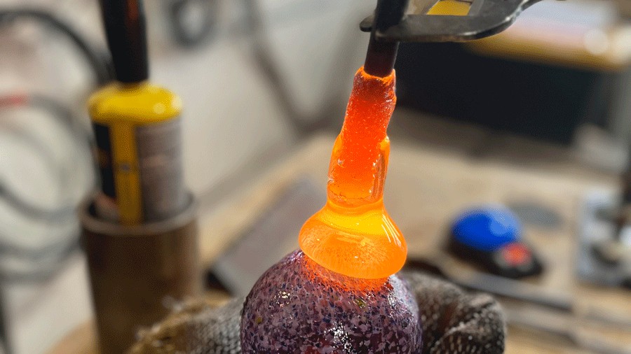 Monkeyshine being made in studio with hot, glowing glass 