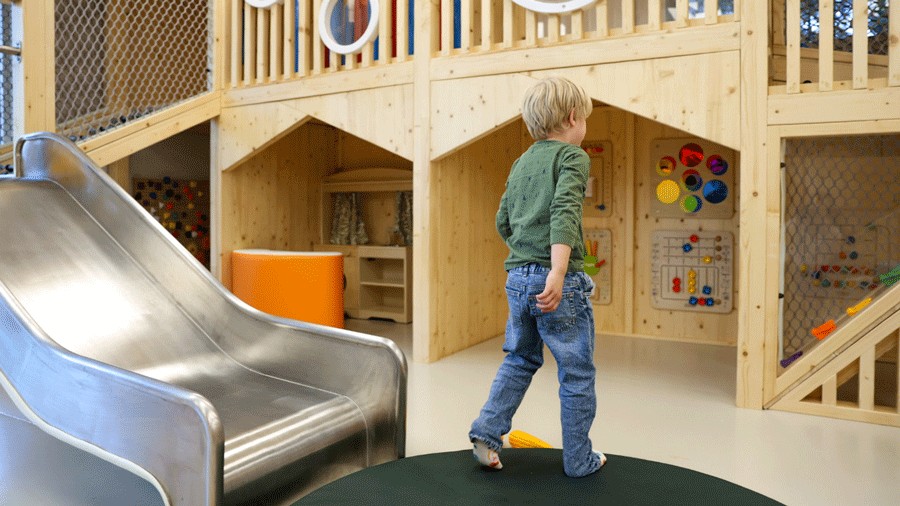 young child walking inside the montessori-inspired play space of Nixi City