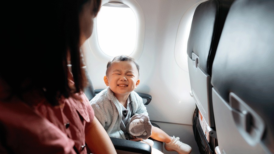 smiling kid on an airplane flying out of Paine Field