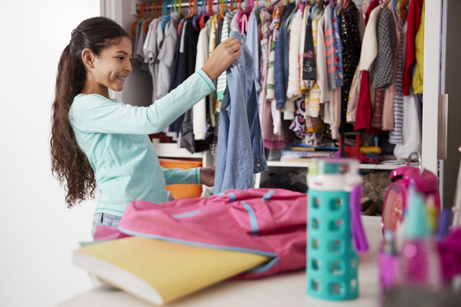 Girl picking out her clothes the night before school