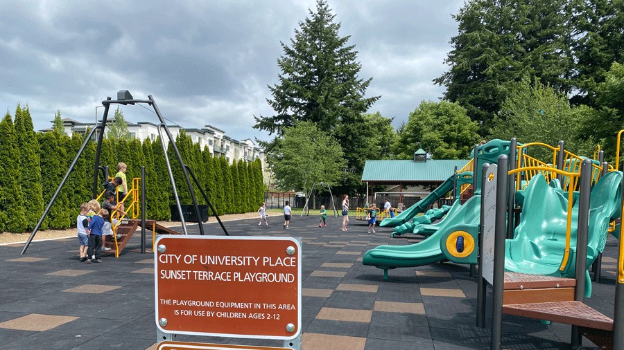 playground age limit sign in front of kids on the playground structure playing