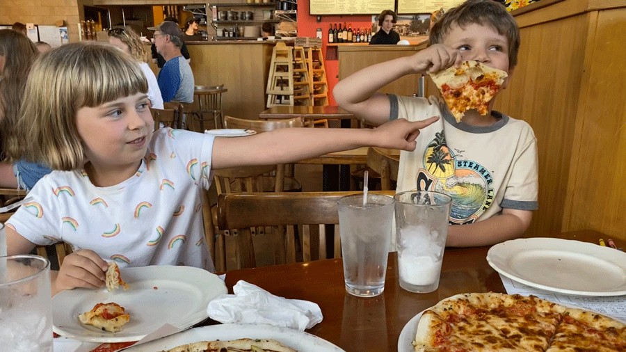 kids eating pizza and smiling with a kids meal at Fondi Pizzeria in Gig Harbor