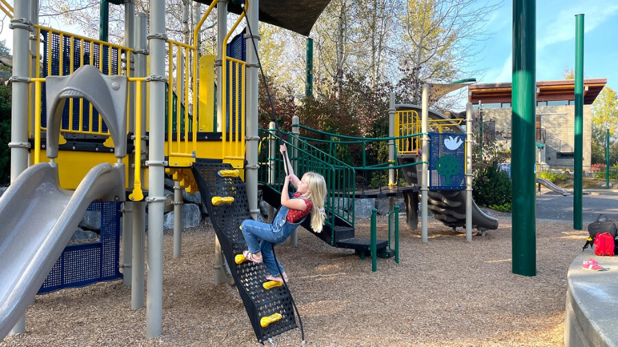 Girls play on the playground at Lewis Creek Park among fun urban nature destinations for Seattle area families