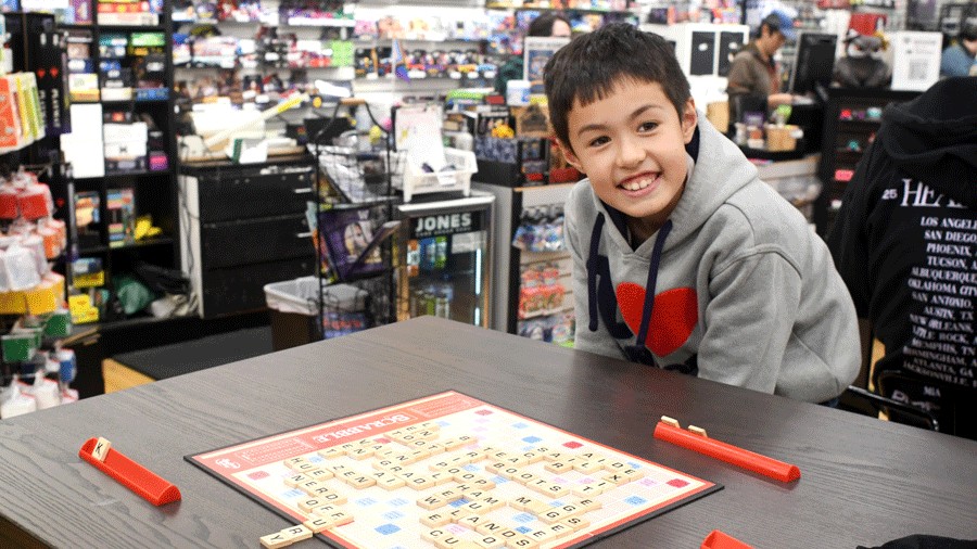 kid playing Scrabble during family game night, a fun thing to do in Redmond