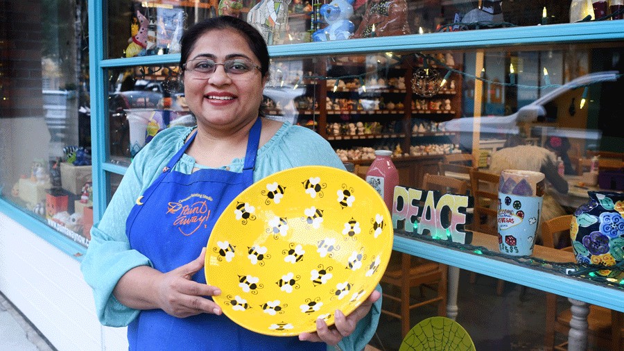 owner of Paint Away holding a plate in front of the shop in Redmond