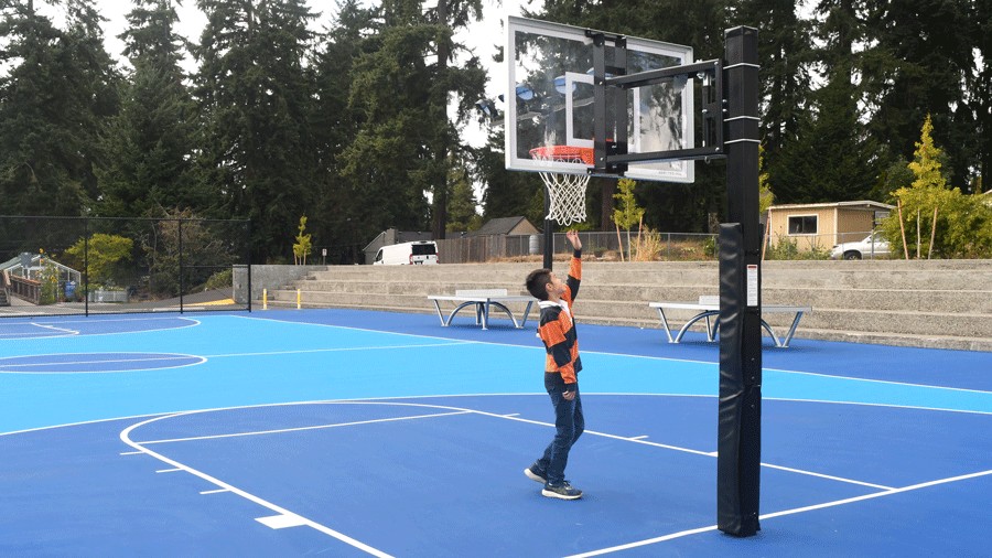 young boy touching adjustable basketball hoop at Richmond Highlands Park