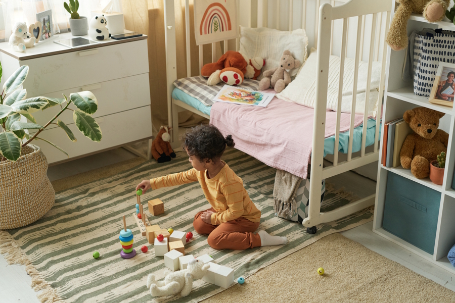 child playing in their room on the floor with rug