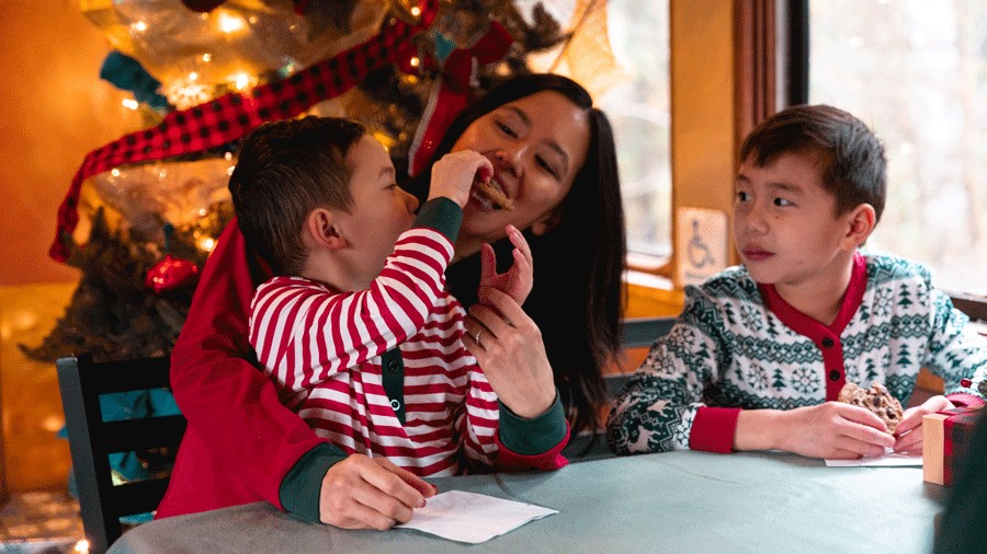 a mom and children enjoying cookies on a Santa train ride