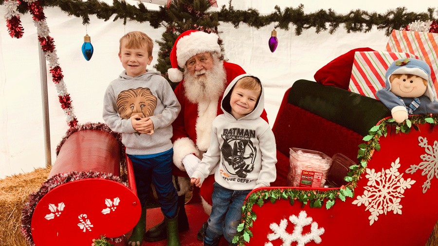 kids posing with Santa at a u-cut Christmas tree farm