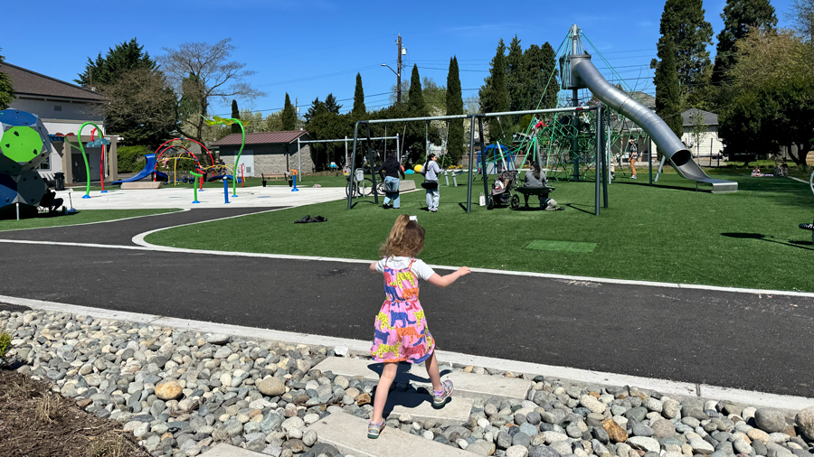 girl crossing path walking toward South Park playground in Seattle