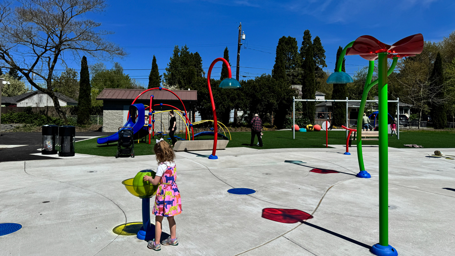 girl touching water features on the South Park Community Center Spray Park